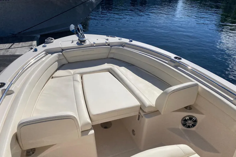 Slide: The Image of 2024 Grady-White Fisherman 236 boat interior with cushioned seating, docked by the water. - 4