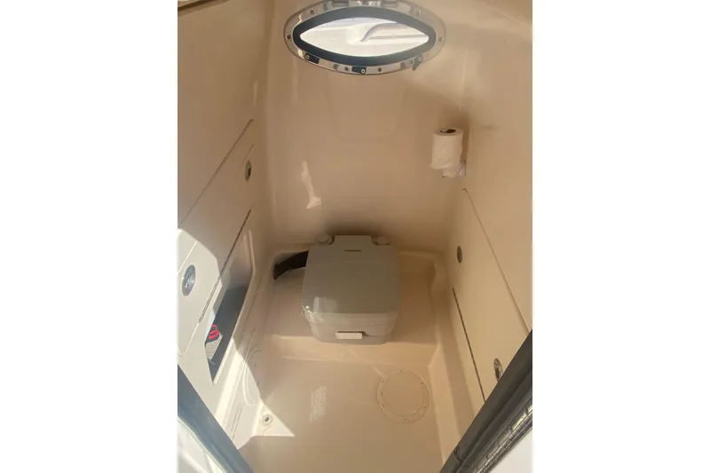 Slide: The Image of 2024 Grady-White Fisherman 236 boat interior with compact toilet and porthole. - 8