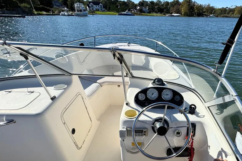 Slide: The Image of 2002 Sea Hunt Escape 200 boat dashboard with steering wheel, gauges, and lake view. - 10