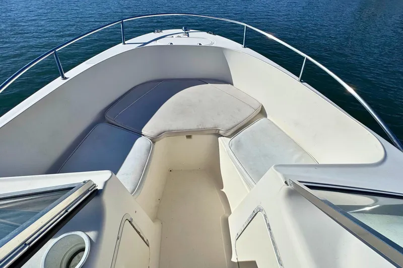 Slide: The Image of 2002 Sea Hunt Escape 200 boat interior with cushioned seating, surrounded by calm water. - 13