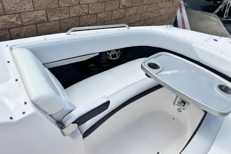 Slide: The Image of 2014 Regal 27 FasDeck boat interior with white seating and a foldable table. - 16