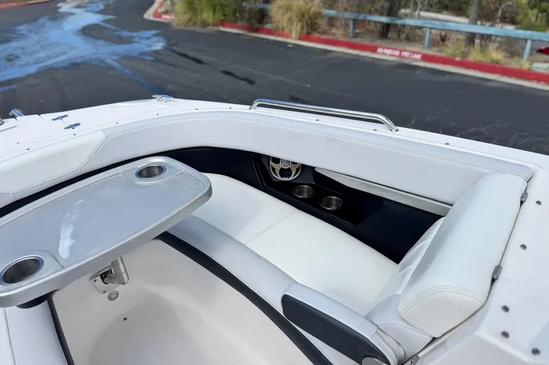 Slide: The Image of 2014 Regal 27 FasDeck boat interior with white seating and cup holders. - 17