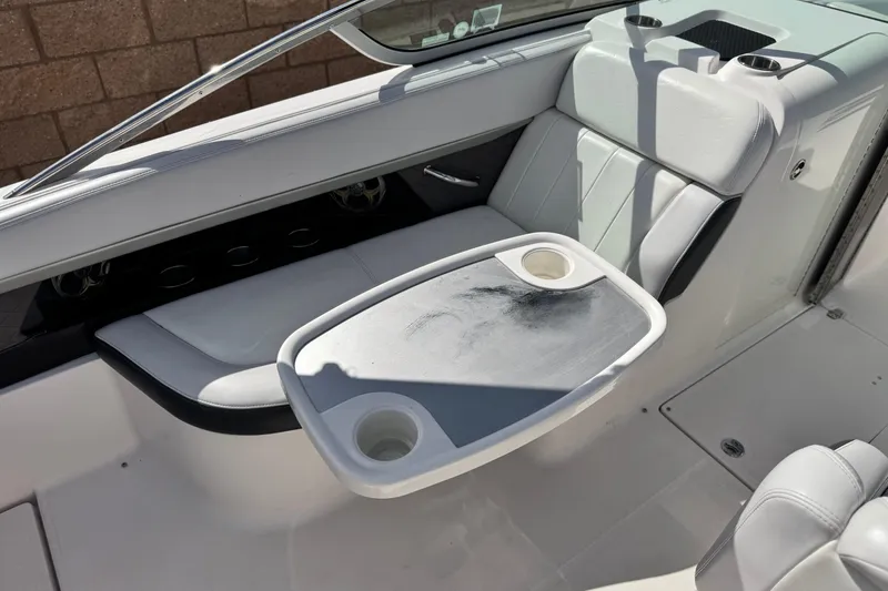 Slide: The Image of 2014 Regal 27 FasDeck boat interior with seating and table, featuring cup holders. - 25