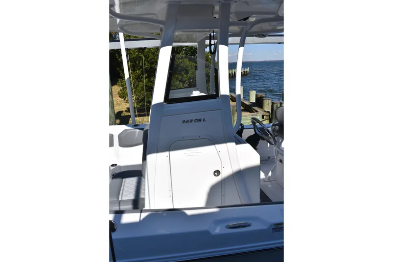 Slide: The Image of 2025 NauticStar 242L Offshore boat interior with helm, dockside view. - 14