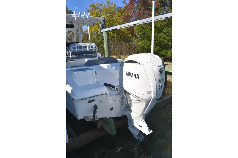 Slide: The Image of 2025 NauticStar 242L Offshore boat with Yamaha 300 outboard motor docked. - 16