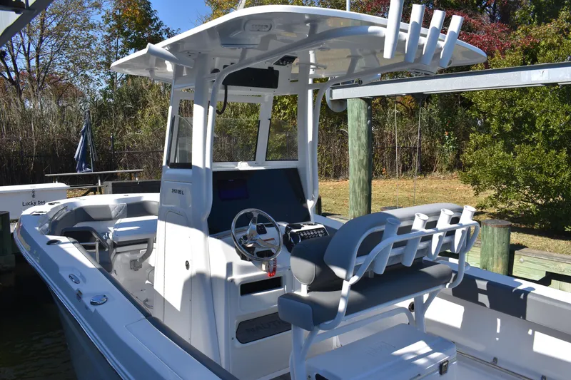 Slide: The Image of 2025 NauticStar 242L Offshore boat with sleek design and modern features, docked outdoors. - 18
