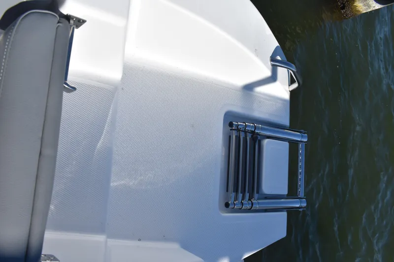 Slide: The Image of 2025 NauticStar 242L Offshore boat with a foldable ladder on the deck. - 20