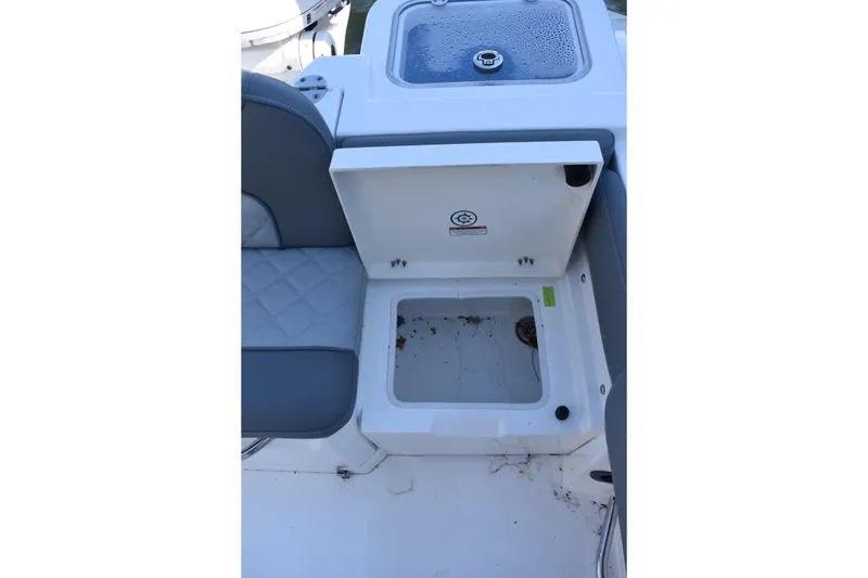 Slide: The Image of 2025 NauticStar 242L Offshore boat storage compartment with cushioned seating. - 28