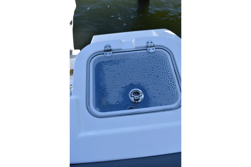 Slide: The Image of 2025 NauticStar 242L Offshore boat livewell with water droplets on the lid. - 29