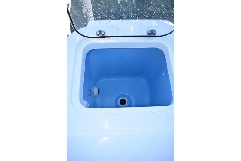 Slide: The Image of Livewell compartment on 2025 NauticStar 242L Offshore boat, featuring a blue interior. - 30