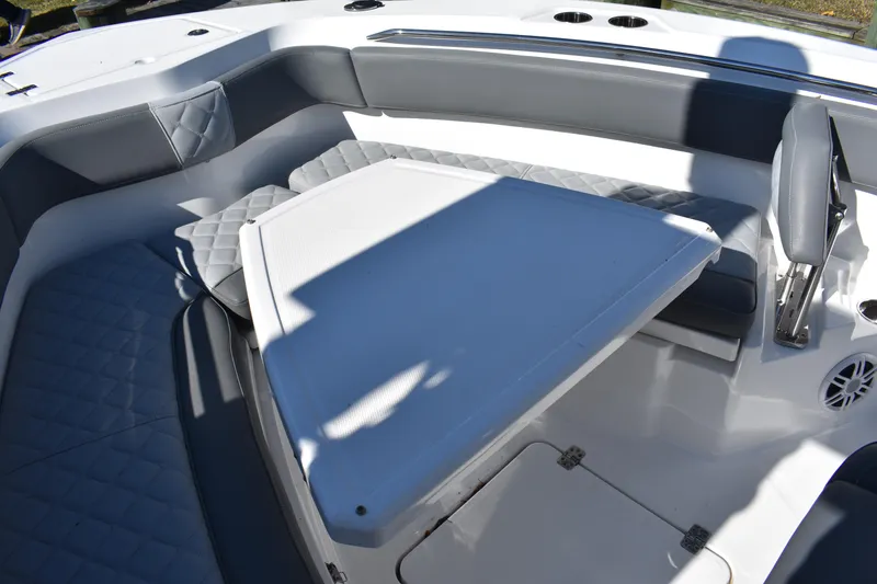 Slide: The Image of 2025 NauticStar 242L Offshore boat interior with cushioned seating and table. - 45