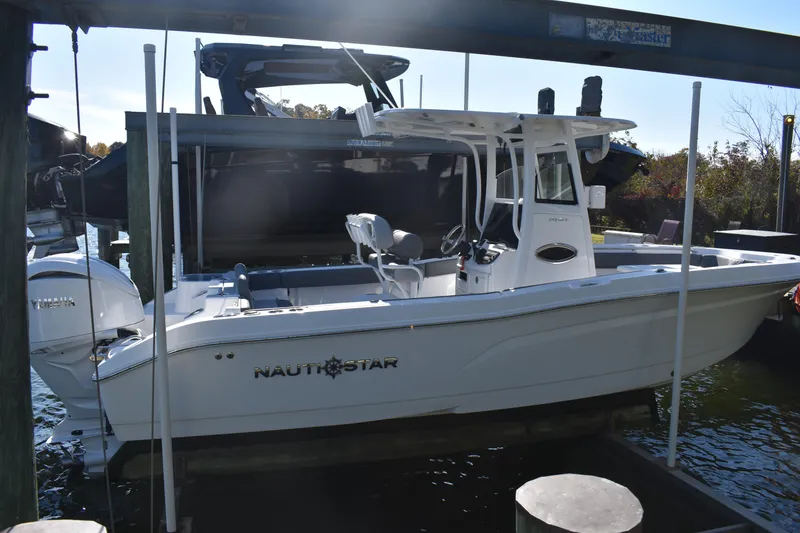 Slide: The Image of 2025 NauticStar 242L Offshore boat docked with Yamaha engine. - 52