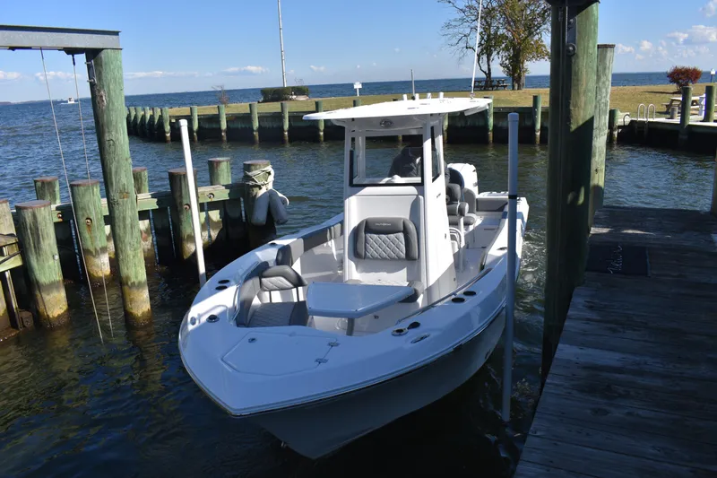 Slide: The Image of 2025 NauticStar 242L Offshore boat docked by a scenic waterfront. - 53