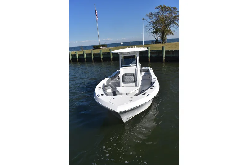 Slide: The Image of 2025 NauticStar 242L Offshore boat docked on calm water, clear sky background. - 54