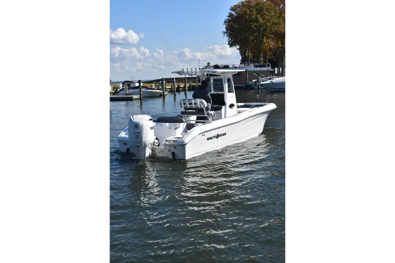 Slide: The Image of 2025 NauticStar 242L Offshore boat on calm water, clear sky background. - 59