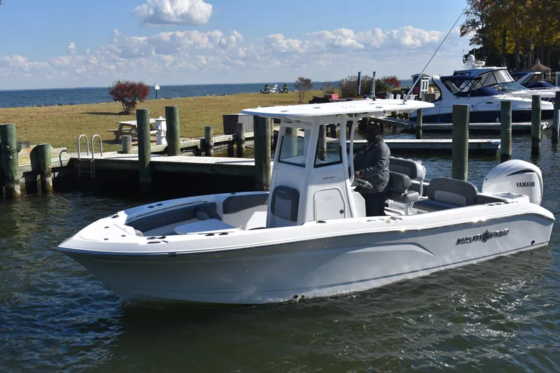 Slide: The Image of 2025 NauticStar 242L Offshore boat docked at marina with Yamaha engine. - 68