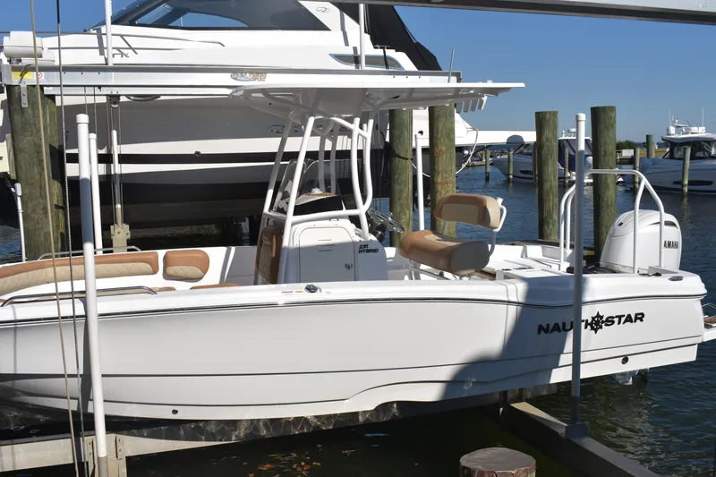 Slide: The Image of 2025 NauticStar 231 Hybrid boat docked at marina, featuring sleek design and Yamaha engine. - 11