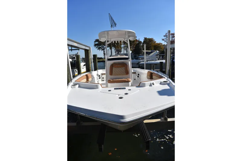 Slide: The Image of 2025 NauticStar 231 Hybrid boat docked, featuring sleek design and comfortable seating. - 12