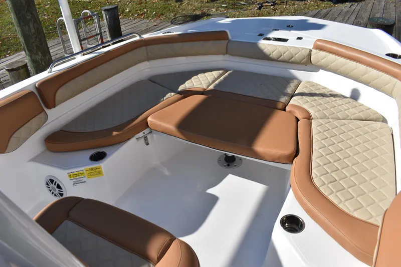 Slide: The Image of 2025 NauticStar 231 Hybrid boat interior with tan and beige cushioned seating. - 20