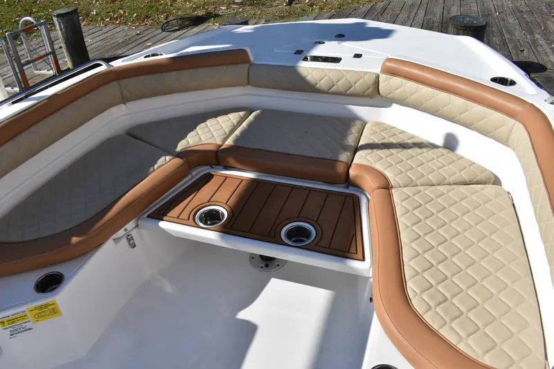 Slide: The Image of 2025 NauticStar 231 Hybrid boat interior with tan quilted seating and wood accents. - 21