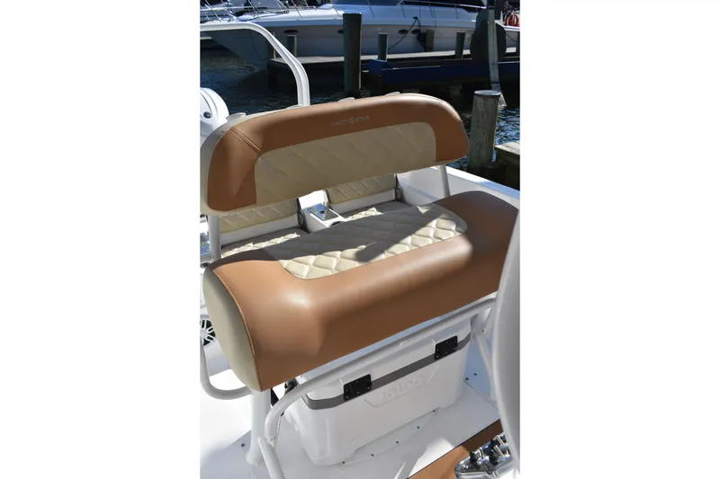 Slide: The Image of 2025 NauticStar 231 Hybrid boat seat with tan and cream upholstery, docked at marina. - 33