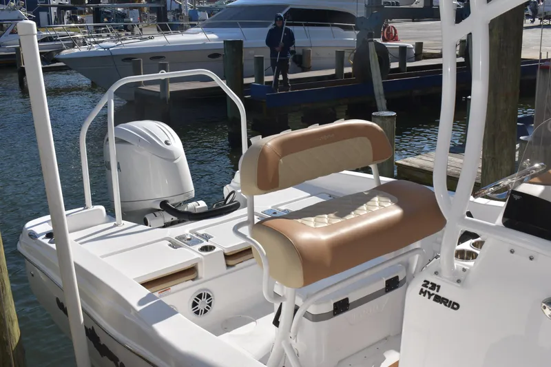 Slide: The Image of 2025 NauticStar 231 Hybrid boat at dock, featuring comfortable seating and powerful outboard motor. - 46