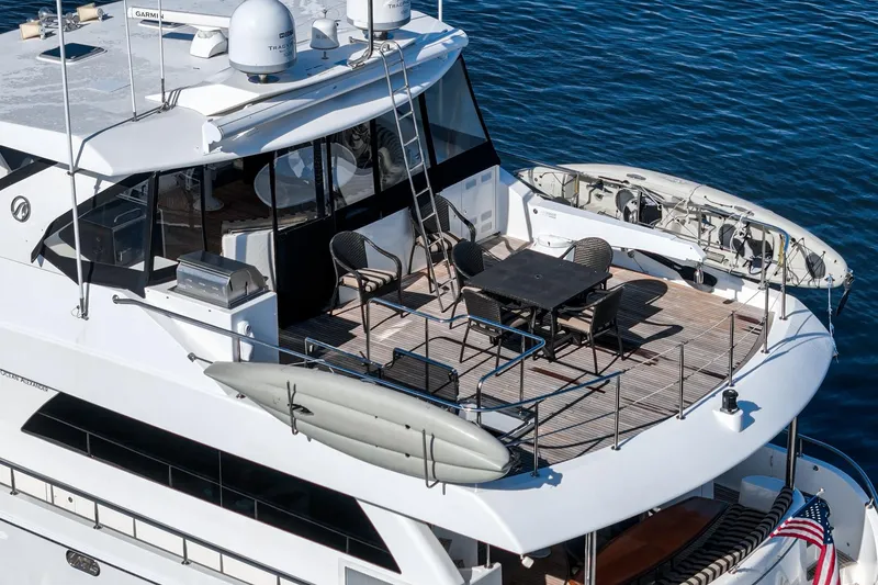 Slide: The Image of 2010 Ocean Alexander Motor Yacht with spacious deck, dining area, and kayak, on calm water. - 30