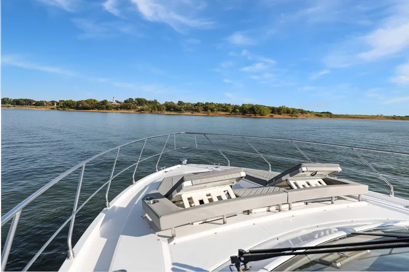 Slide: The Image of 2022 Cruisers Yachts 54 Cantius on serene water with clear blue sky. - 19