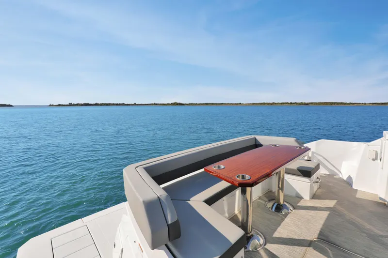 Slide: The Image of Luxury seating area on 2022 Cruisers Yachts 54 Cantius overlooking serene blue waters. - 25