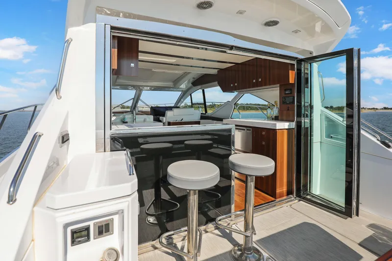 Slide: The Image of 2022 Cruisers Yachts 54 Cantius interior with bar stools and open sliding doors. - 26