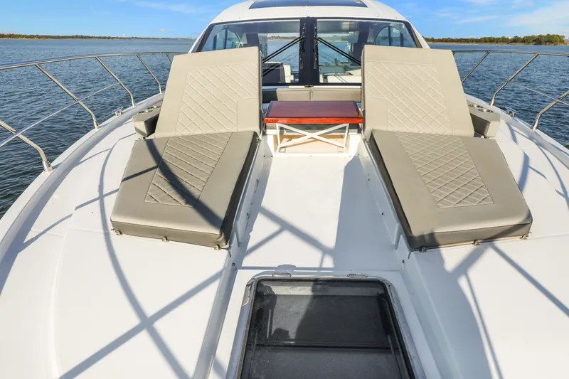 Slide: The Image of 2022 Cruisers Yachts 54 Cantius with sun loungers on deck, cruising on open water. - 38