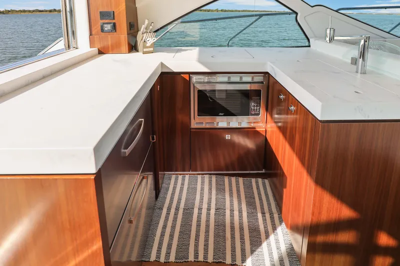 Slide: The Image of Luxurious 2022 Cruisers Yachts 54 Cantius kitchen with modern appliances and elegant wood cabinetry. - 45