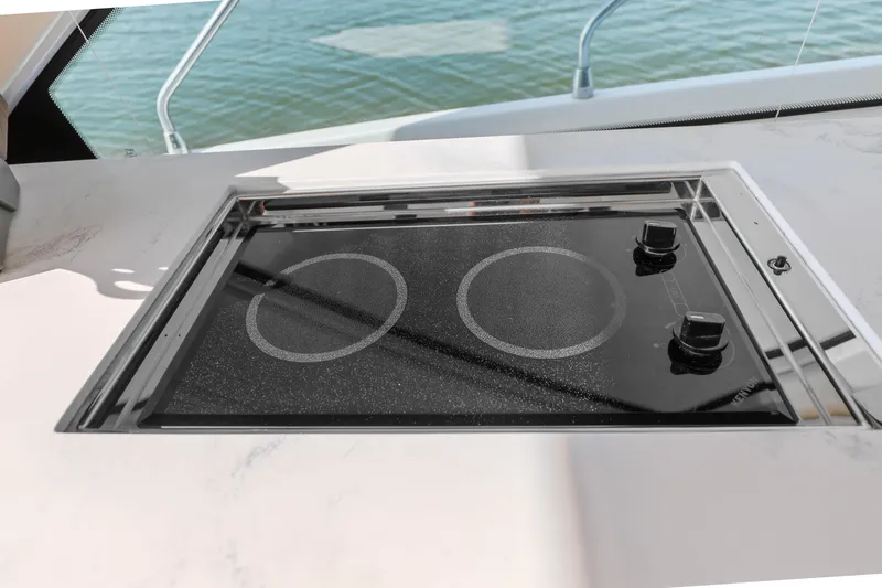 Slide: The Image of Built-in stovetop on 2022 Cruisers Yachts 54 Cantius, overlooking water. - 47