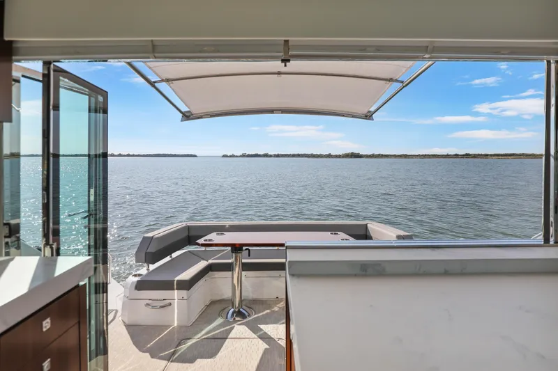 Slide: The Image of 2022 Cruisers Yachts 54 Cantius, open deck view, overlooking serene water and clear sky. - 48