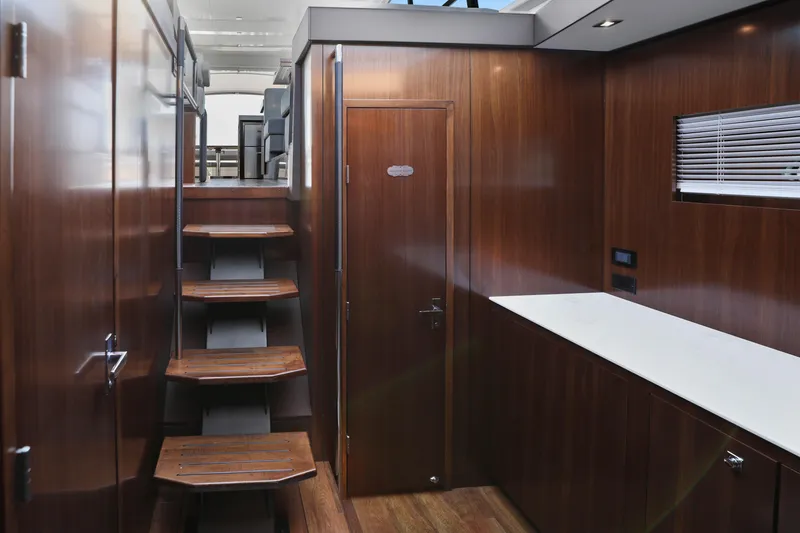 Slide: The Image of Interior of 2022 Cruisers Yachts 54 Cantius, featuring wooden stairs and modern design. - 60