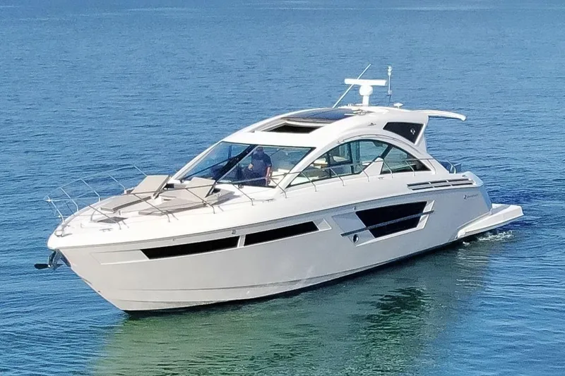 Slide: The Image of 2022 Cruisers Yachts 54 Cantius luxury yacht cruising on clear blue water. - 7