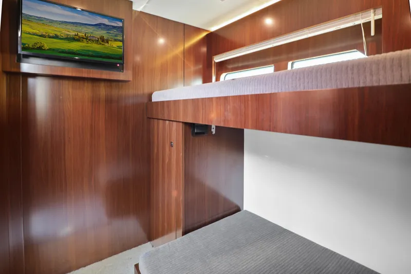Slide: The Image of 2022 Cruisers Yachts 54 Cantius cabin with wooden interior and wall-mounted TV. - 73