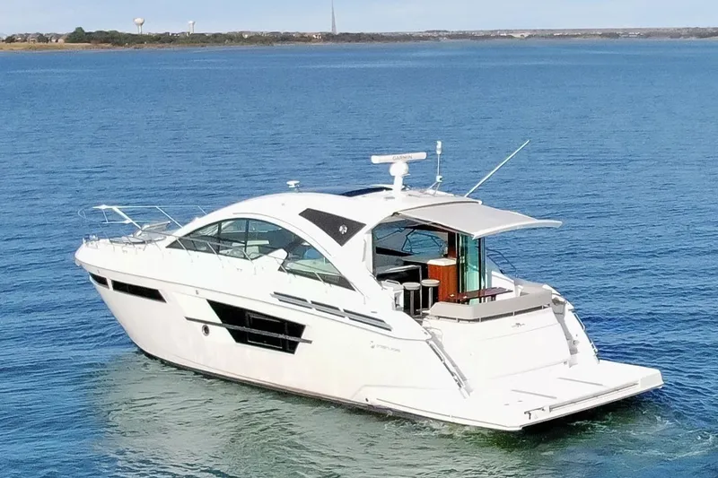 Slide: The Image of 2022 Cruisers Yachts 54 Cantius on serene blue water, showcasing sleek design and luxury. - 9