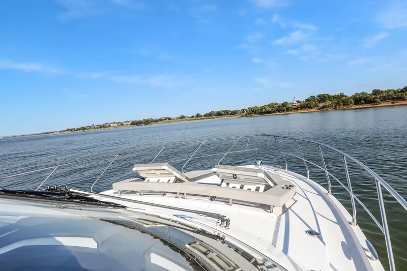 Slide: The Image of 2022 Cruisers Yachts 54 Cantius on serene water with clear blue sky. - 16