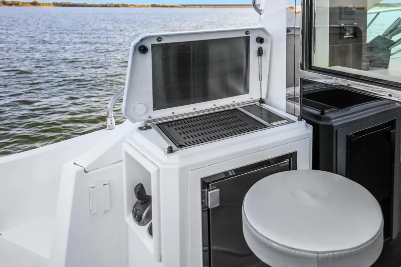 Slide: The Image of Outdoor kitchen area on 2022 Cruisers Yachts 54 Cantius, featuring grill and seating. - 20