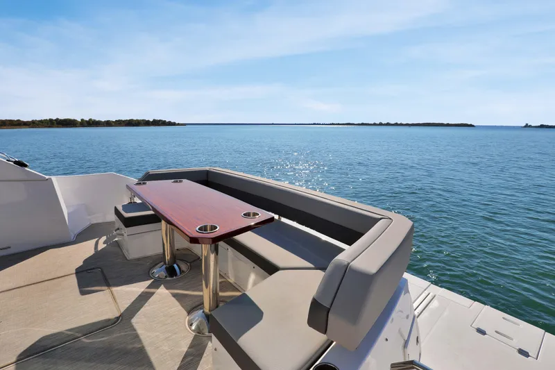 Slide: The Image of Luxurious 2022 Cruisers Yachts 54 Cantius with elegant seating overlooking serene waters. - 24