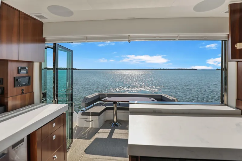 Slide: The Image of Interior view of 2022 Cruisers Yachts 54 Cantius, overlooking serene ocean waters. - 33