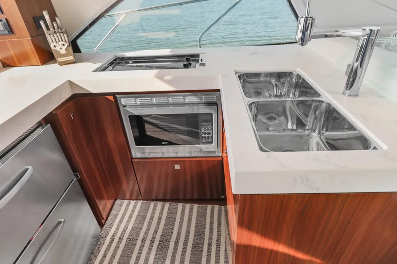 Slide: The Image of Luxurious kitchen in 2022 Cruisers Yachts 54 Cantius with modern appliances and dual sinks. - 46