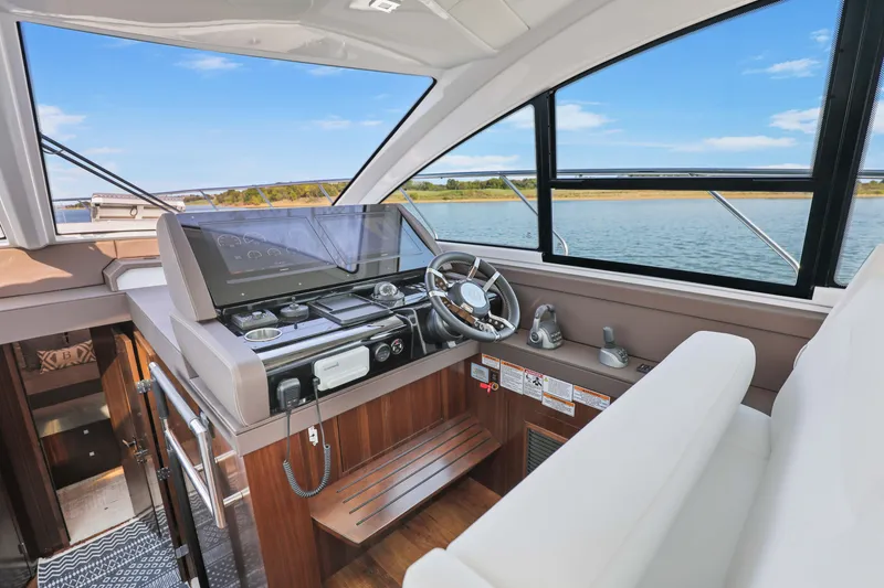 Slide: The Image of 2022 Cruisers Yachts 54 Cantius helm with modern controls and scenic water view. - 50
