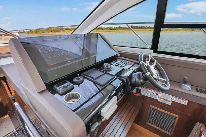 Slide: The Image of Helm of 2022 Cruisers Yachts 54 Cantius with modern controls and scenic water view. - 51