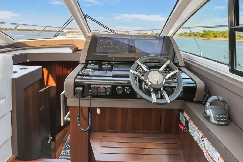 Slide: The Image of 2022 Cruisers Yachts 54 Cantius helm with modern controls and panoramic view. - 54