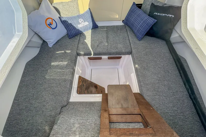 Slide: The Image of Interior of 2026 Axopar 29 Sun Top boat with cushioned seating and decorative pillows. - 11