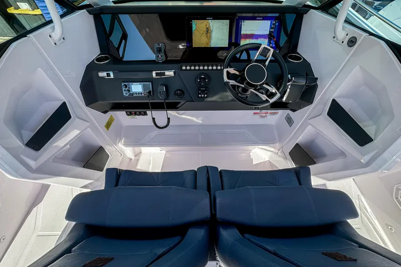 Slide: The Image of 2026 Axopar 29 Sun Top boat cockpit with modern navigation controls and dual seats. - 16