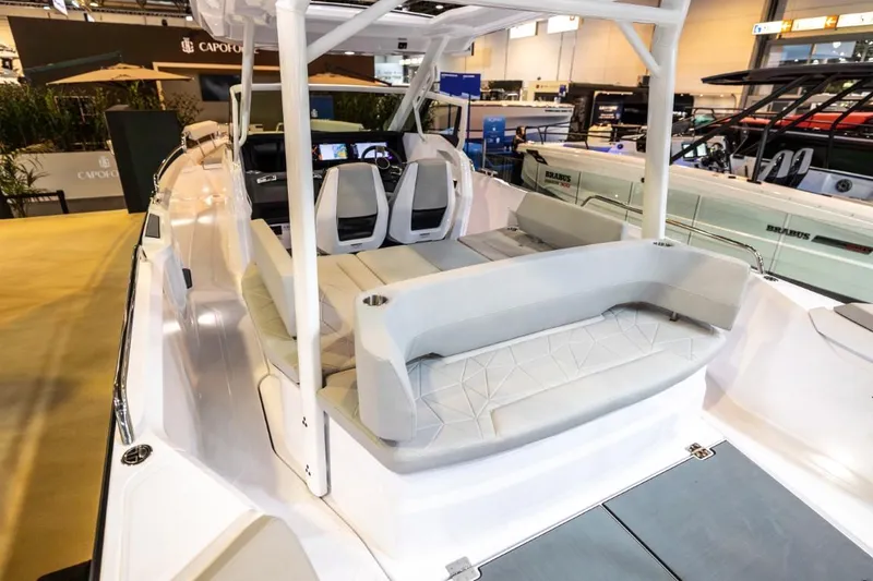 Slide: The Image of 2025 Axopar 29 Sun Top boat interior with seating and helm, showcased indoors. - 6