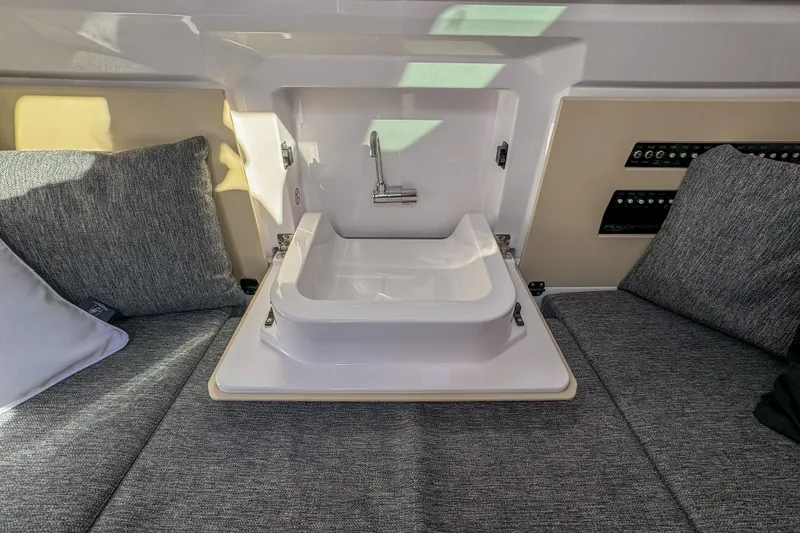 Slide: The Image of Interior of 2026 Axopar 29 Sun Top with compact sink and gray cushions. - 13
